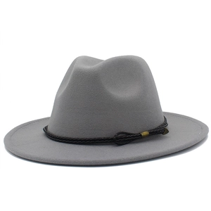 Detail of wool fedora hat with dark brown braided leather band and gold metal hardware