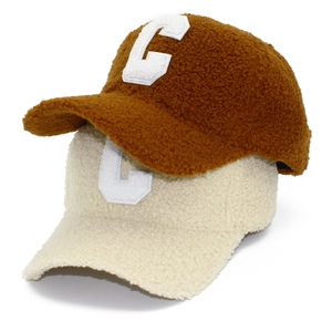 Close-up of teddy fleece baseball caps in brown and beige with embroidered C logo