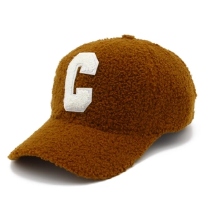 Macro detail of the fuzzy caramel teddy fleece texture and white letter C embroidery
