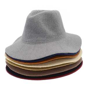 Detailed stack of colorful knit fedora hats in grey, blue, orange, and beige tones