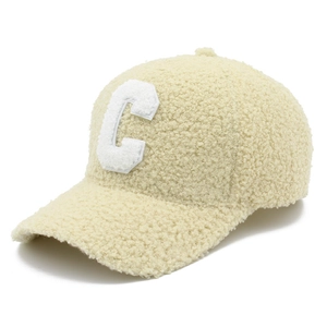 Detailed close-up of cream lamb wool baseball cap featuring white fleece letter C patch