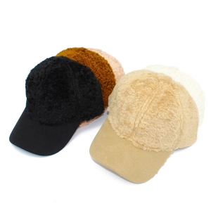 Detail view of plush baseball caps in black, brown, khaki, and beige colors