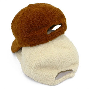 Detail of adjustable velcro straps on plush lamb wool baseball caps in brown and beige