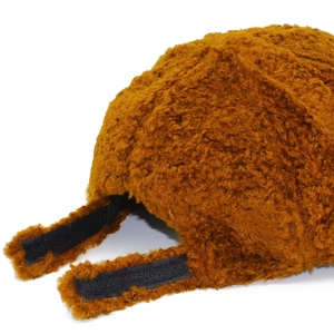 Detail of plush brown teddy baseball cap showing adjustable black velcro strap closure