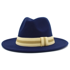Detailed close-up of dark blue wool fedora hat with striped beige decorative band