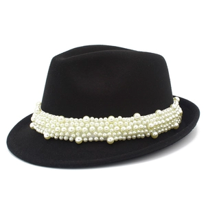 Detail of elegant black wool Fedora hat featuring luxury white pearl embellishments around the base