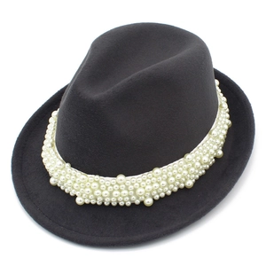 Detail of elegant black wool jazz hat featuring white pearl embellishments on the band