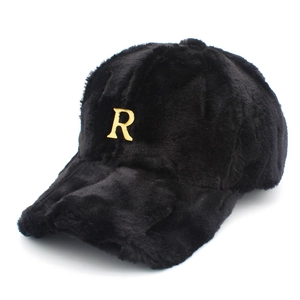 Detalle de la textura de piel sintética negra y la letra R de metal dorado en la gorra de béisbol