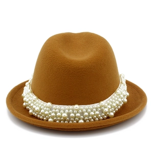 Detail of a brown wool jazz hat featuring an elegant multi-layered white pearl headband embellishment