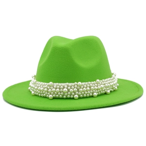 Détail de perles blanches multicouches sur le bord d'un chapeau en feutre vert vif