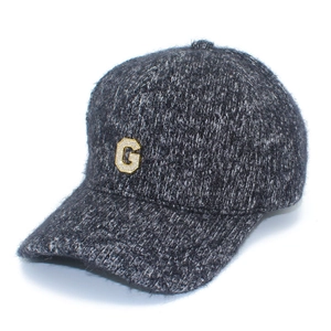 Détail d'une casquette en maille gris foncé avec un logo lettre G serti de cristaux