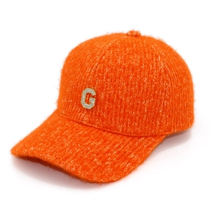 Détail d'une casquette de baseball orange pelucheuse avec logo G en strass brillant