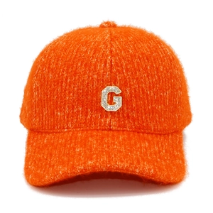 Détail d'une casquette de baseball en tricot orange avec logo lettre G en cristaux