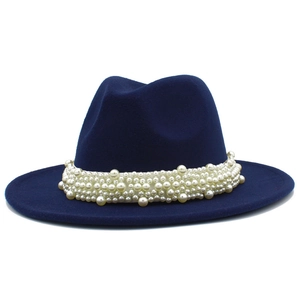 Détail de grosses perles blanches sur un chapeau fedora bleu marine à large bord plat