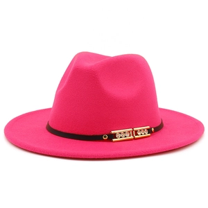 Detail of rose red wool fedora hat featuring black band and gold buckle with crystals
