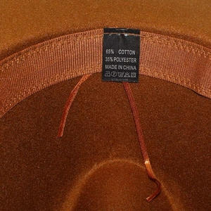 Detail of inner care label and adjustable drawstring on plaid fedora jazz hat