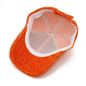 Détail de l'intérieur d'une casquette en maille orange avec bande et fermeture velcro réglable