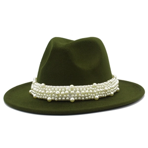 Détail du chapeau fedora en laine vert foncé avec bande décorative en perles blanches
