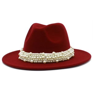 Détail d'un élégant chapeau fedora bordeaux à larges bords avec bande de perles