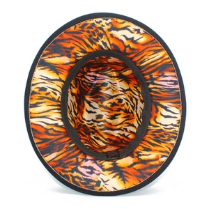 Detailed interior of fedora hat showing vibrant orange tiger print lining and sweatband