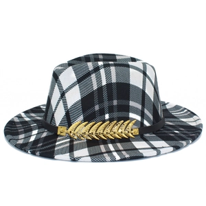 Detailed close-up of the black and white plaid pattern and gold feather pin on a fedora hat
