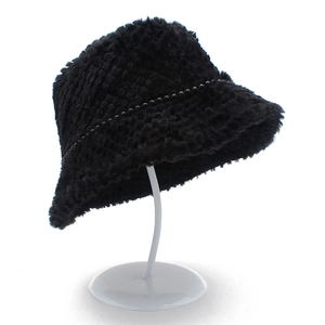 Gros plan d'un chapeau cloche en peluche noire avec bordure perlée sur support blanc