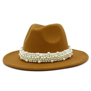 Detalle de sombrero fedora de lana marrón con elegante banda de perlas blancas grandes