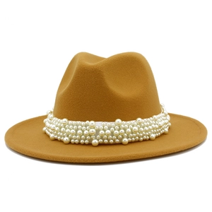 Détail d'un chapeau fedora élégant en laine camel avec bandeau luxueux en perles