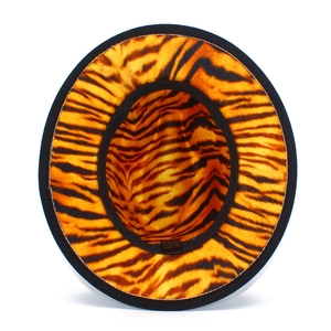 Detail view of the orange tiger print interior lining and 65% cotton care label inside the hat