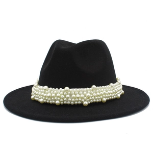 Détail d'un chapeau fedora noir élégant montrant des perles sur le ruban décoratif