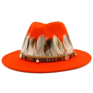 Detail of orange fedora with natural feather band, woven strap and ethnic metal charms