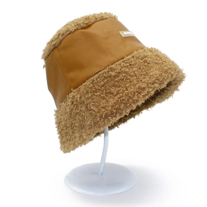 Chapeau seau d'hiver en similicuir et laine d'agneau marron et beige sur un support blanc