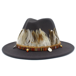 Detail of grey fedora with feather accents, ethnic woven band and silver coin charms