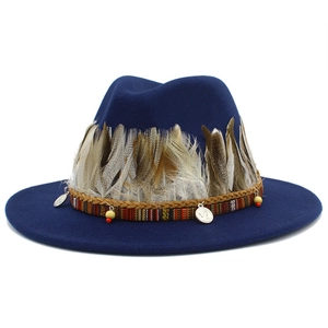 Detail of navy fedora hat with ethnic feathers, woven band, and antique coin charms