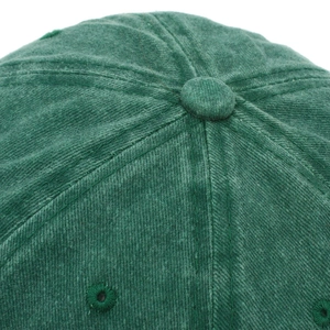 Macro shot of green corduroy baseball cap crown with button and stitched eyelets