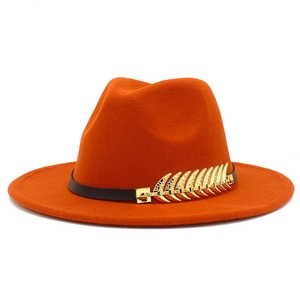 Close-up of orange wool fedora featuring a black leather band and golden feather pin