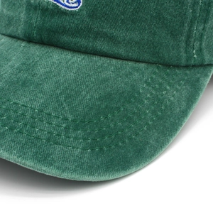 Macro shot of dark green washed cotton baseball cap with detailed stitching and embroidery