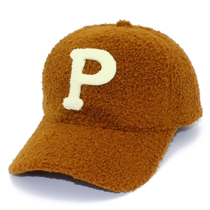 Close-up of the fluffy brown lamb wool texture and white P letter embroidery on the cap