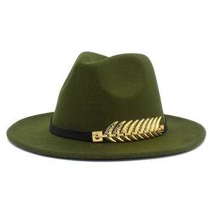 Close-up of olive green fedora hat featuring a gold metal leaf accessory on leather band