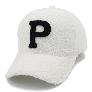 Detail of white sherpa baseball cap with black letter P patch and plush fleece texture