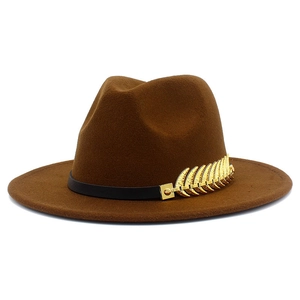 Detail of a brown fedora hat featuring a black band and a golden feather metal ornament