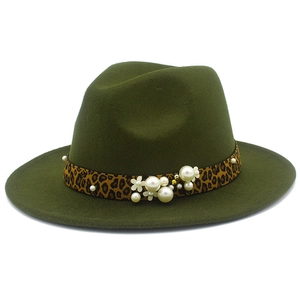 Détail du chapeau en feutre vert avec ruban léopard, perles blanches et petites fleurs