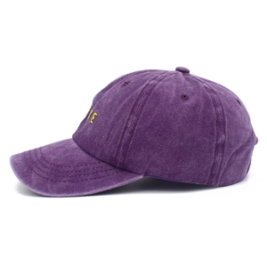 Detail view of vintage washed purple baseball cap with yellow letter embroidery on the side