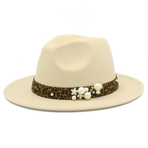Détail d'un chapeau en laine avec ruban léopard, perles et fleurs blanches