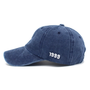 Detail view of the white 1999 embroidery on this dark blue washed denim baseball cap
