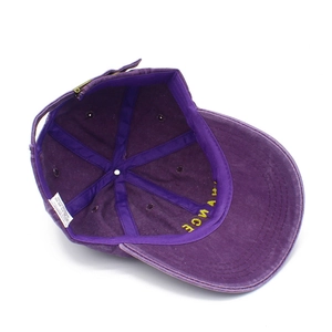 Detail of purple cotton baseball cap interior showing metal buckle and white wash label