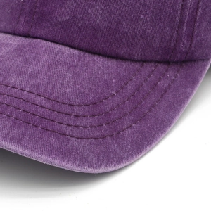 Close-up of vintage washed purple cotton baseball cap with triple-stitched brim detail