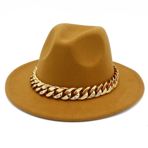 Detail of camel wool fedora hat featuring a chunky gold acrylic curb chain decoration