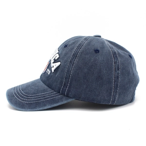 Detail of washed denim baseball cap with white ICA 1776 embroidery and vintage texture
