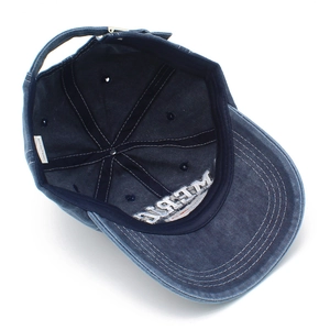 Detail of the internal cotton lining, stitching, and 100% cotton label of a denim cap